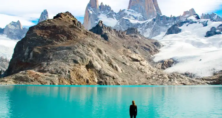 Persona mirando un lago y montañas