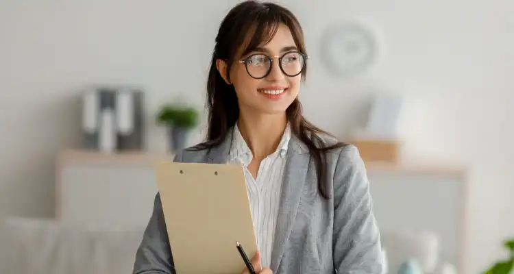 Mujer con lentes sujetando una carpeta y un làpiz