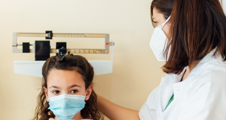 Niña siendo medida por una doctora