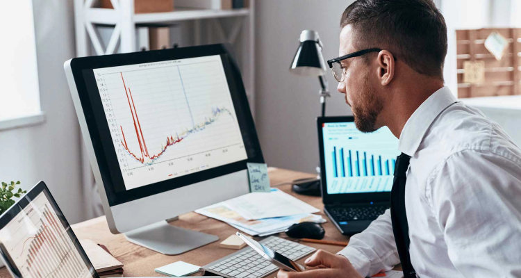 Hombre mirando gráficos en la pantalla de su computador