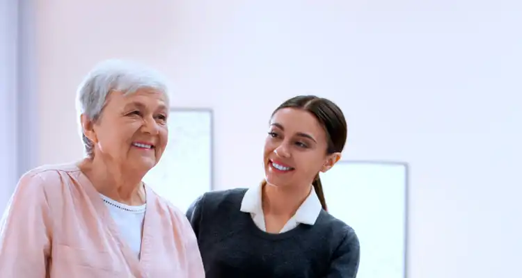 Mujer joven sonriendo junto a una anciana