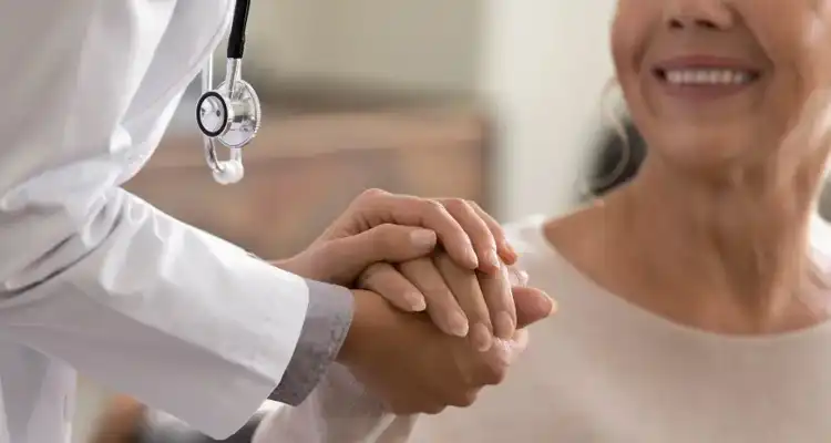 Médico tomando la mano de una paciente adulta