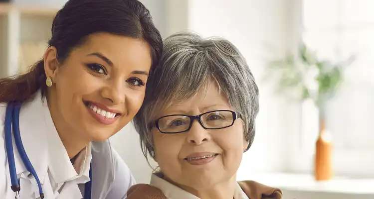 Imagen de una mujer médico junto a una mujer de la tercera edad