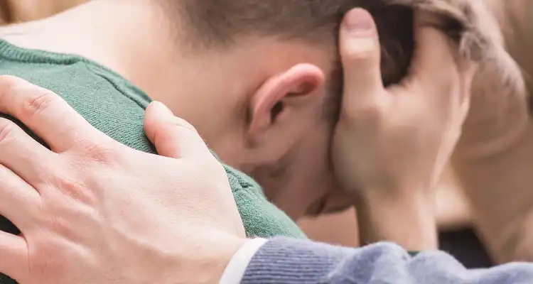 Hombre sosteniendo su cabeza con sus manos