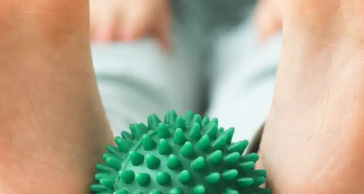 Persona sosteniendo una pelota verde de goma