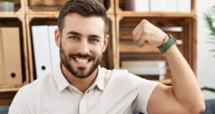 Hombre sonriendo y levantando un brazo con un reloj